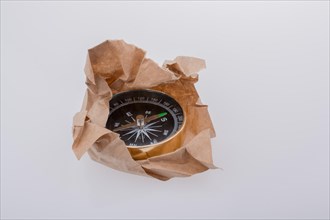 Black compass instrument wrapped in brown paper