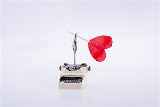 Heart shape icon on a typewriter on white background