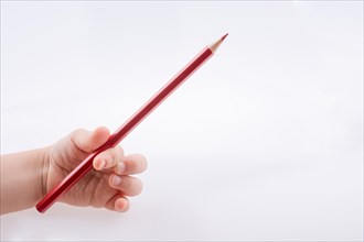 Hand holding a red color pencil on a white background