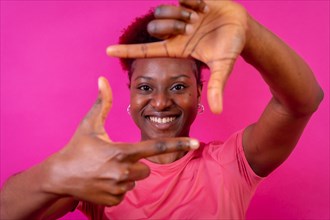 Young african american woman isolated on a pink background with gesture square from fingers