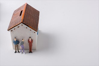 Figurine of men and poor invalid man beside house