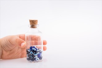 Little glass bottle with blue evil eye bead in hand