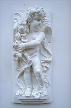 Childlike angel figure on the wall of a noble architecture in the villa district of Sassnitz