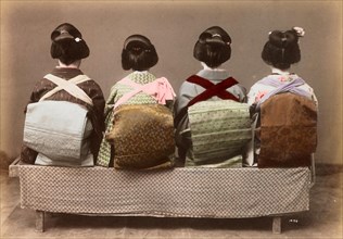 Four Japanese woman in traditional dress sitting side by side