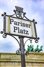 Sign Pariser Platz at the end of the street Unter den Linden with the Brandenburg Gate in the background