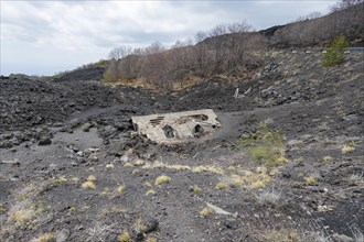 House buried by lava in the volcanic landscape of Etna