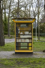 Historic yellow telephone box in the village of Luebars