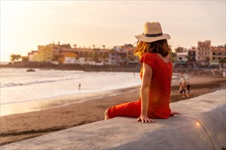 Tourist woman with hat at sunset on vacation on the beach of Valle Gran Rey village on La Gomera