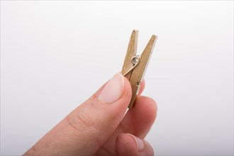 Hand holding a small wooden clothespin in hand