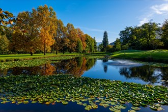 Golf Course with Water Pond and Autumn Trees in a Sunny Day in Lugano