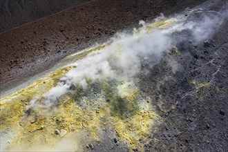 Smoking sulphur fumaroles at the crater rim
