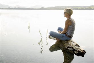 Woman sitting relaxed on a stone