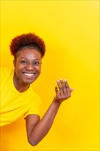 Young african american woman isolated on a yellow background inviting to come with her hand