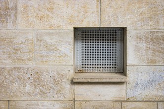 A ventilation shaft with a grille in a wall