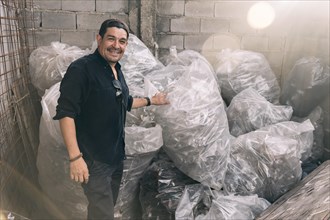 Man smiling and looking at camera showing his recycling work