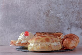 Assortment of cream and custard cakes on a black slate and gray background