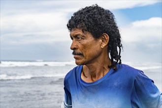 Profile portrait of a native man with mustaches looking out to sea