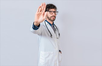 Serious doctor making stop gesture on isolated background