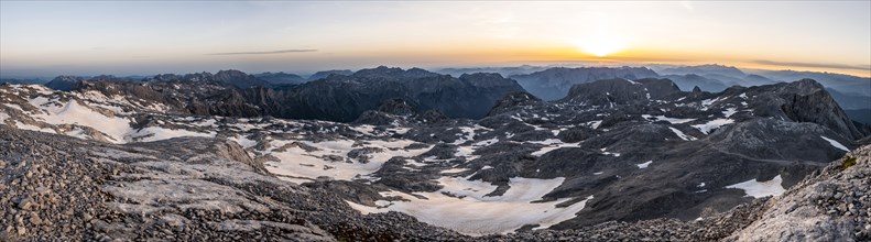 PanoramaView of rocky plateau with snow and glacier at sunrise