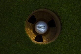Golf Ball in the Hole on Putting Green with Text Practice in Switzerland