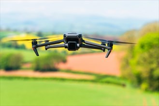 Drone in flight over fields and farms