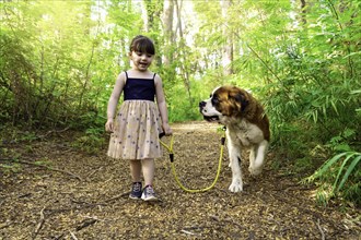 Girl walking with her dog in a forest