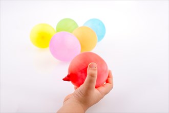 Hand holding a Colorful small balloon with colorful balloons on the white background
