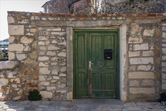 Green wooden door on an old stone house in the coastal town of Umag
