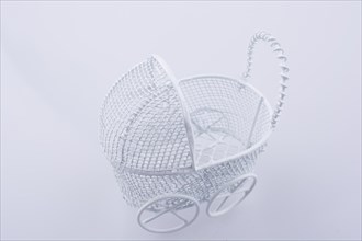 Toy baby carriage made of metal on white background