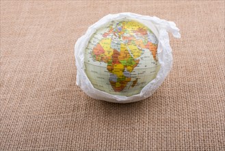 Globe wrapped with paper placed on canvas background