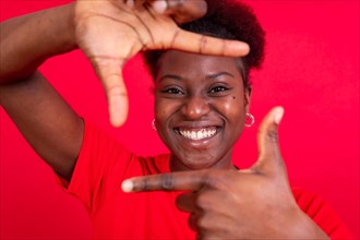 Young african american woman isolated on a red background with gesture square from fingers