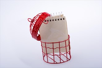 Little notebook placed in a red color bird house with metal bars