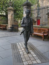 Life-size statue of the Scottish poet Robert Fergusson in front of Canongate Kirk