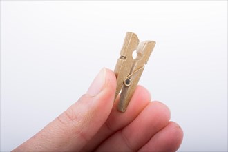 Hand holding a small wooden clothespin in hand