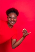 Young african american woman isolated on a red background inviting to come with her hand