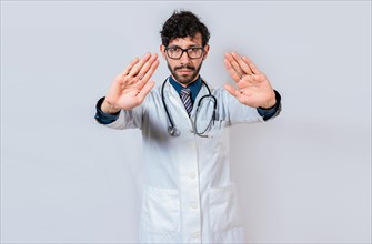 Doctor making a stop gesture with palms on isolated background. Young doctor making a stop gesture with his hands isolated