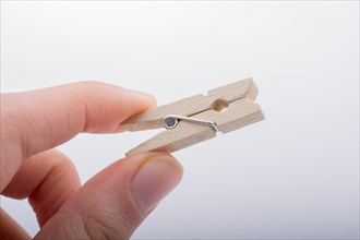 Hand holding a small wooden clothespin in hand