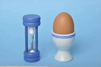 Boiled egg and hourglass on a blue background