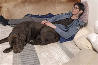 Young woman with her sleeping Labrador