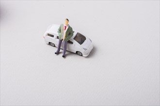 Tiny figurine of man before a miniature car