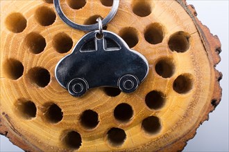 Automobile business concept with a metal car icon on wooden log
