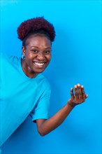 Young african american woman isolated on a blue background inviting to come with her hand