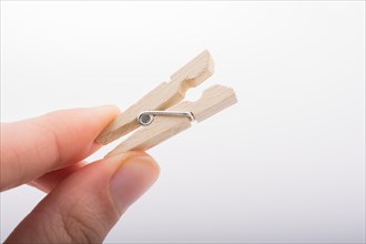 Hand holding a small wooden clothespin in hand