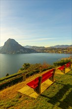 Bench on Lake Lugano and City with Mountain and Blue Sky in Park San Michele in Castagnola in Lugano