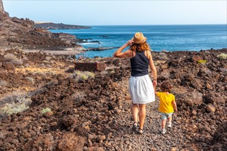 Mother and son walking on a path along the beach at Tacoron on El Hierro