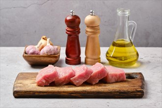 Slices of raw pork top loin roast on wooden cutting board