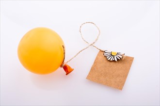 Balloon tied to a note paper with a floral pattern on a white background