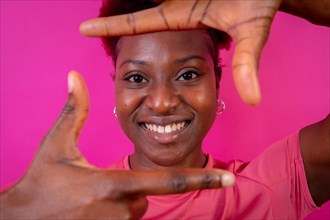 Young african american woman isolated on a pink background with gesture square from fingers