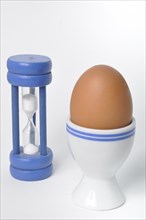 Boiled egg and hourglass on a white background