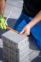 Man measuring stones for natural stone paving